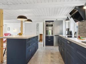une cuisine avec des armoires et des comptoirs bleus dans l'établissement Holiday Home Alisa - from the sea in NE Jutland by Interhome, à Hadsund