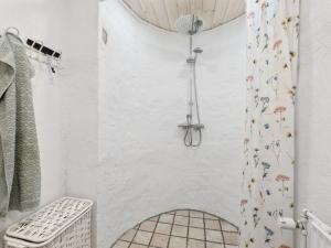 La salle de bains blanche est pourvue d'une douche avec rideau de douche. dans l'établissement Holiday Home Alisa - from the sea in NE Jutland by Interhome, à Hadsund
