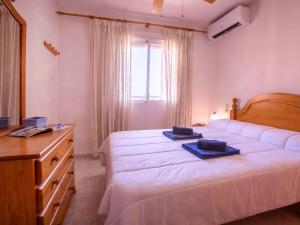 a bedroom with a bed and a dresser with towels on it at Apartment Dianium-1 by Interhome in Denia