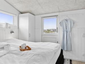 um quarto branco com uma cama e uma janela em Holiday Home Rieke - 40m from the sea in NW Jutland by Interhome em Hjørring