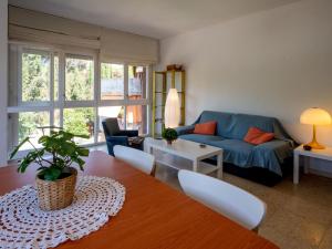 sala de estar con sofá azul y mesa en Apartment Els Pins by Interhome, en Sant Vicenç de Montalt