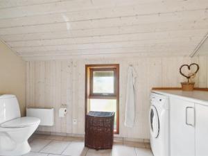 uma casa de banho com um WC e uma máquina de lavar roupa em Holiday Home Henri - 500m from the sea in NW Jutland by Interhome em Fjerritslev