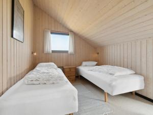 - 2 lits dans une petite chambre avec fenêtre dans l'établissement Holiday Home Henri - 500m from the sea in NW Jutland by Interhome, à Fjerritslev