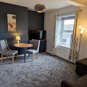 a living room with a table and chairs and a window at The Old Albion at Plover Cottage Lindley in Huddersfield