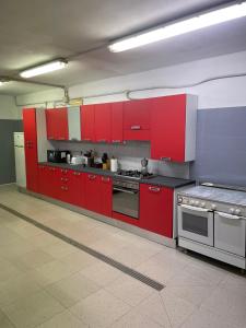 uma cozinha com armários vermelhos e um fogão em Country House Le Marche em Monte San Pietrangeli