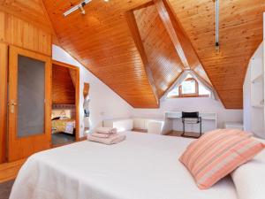 a bedroom with a white bed with a wooden ceiling at Apartment Mainera by Interhome in Sort