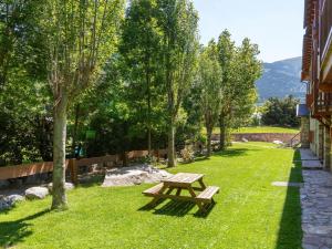 una mesa de picnic en el césped junto a un edificio en Apartment Pla Ermita Isard by Interhome, en Pla de l'Ermita