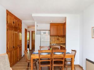 a kitchen and dining room with a wooden table and chairs at Apartment Pla Ermita Isard by Interhome in Pla de l'Ermita