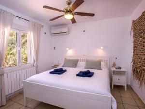 um quarto com uma cama branca e uma ventoinha de tecto em Villa Alsing by Interhome em Xàbia