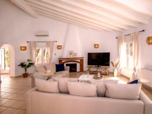 uma sala de estar com um sofá branco e uma televisão em Villa Alsing by Interhome em Xàbia