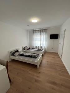 2 Betten in einem Zimmer mit Holzböden in der Unterkunft Übernachtung by Tag in Staufenberg