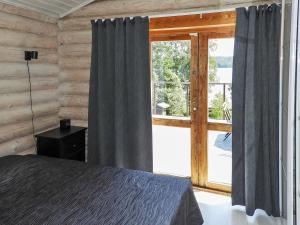 ein Schlafzimmer mit einem Bett und einem großen Fenster in der Unterkunft Holiday Home Hiidenlumo by Interhome in Vihti