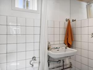y baño blanco con lavabo y ducha. en Holiday Home Cordelia - 1km from the sea in NW Jutland by Interhome, en Skagen