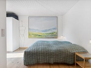 1 dormitorio con 1 cama y una pintura en la pared en Holiday Home Cordelia - 1km from the sea in NW Jutland by Interhome, en Skagen