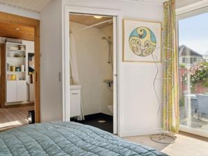 a bedroom with a bed and a door to a bathroom at Holiday Home Cordelia - 1km from the sea in NW Jutland by Interhome in Skagen