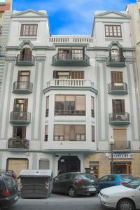 un edificio blanco con coches estacionados frente a él en Beds & Breaks Strauss, en Valencia