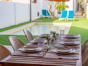 Una mesa de madera con platos y fuentes encima. en Holiday Home Rita by Interhome, en Malgrat de Mar