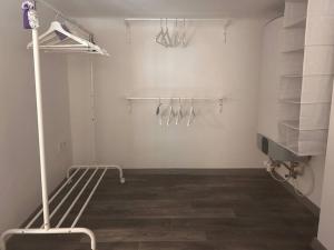 Habitación blanca con armario con perchas y zapatos en GabEni Home en Budapest
