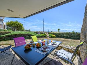 a blue table with a bowl of fruit on a patio at Apartment Les Horizons-2 by Interhome in Carnac