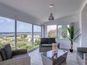 ein Wohnzimmer mit Sofas und einem Tisch und Fenstern in der Unterkunft Apartment La Bellanda by Interhome in Six-Fours-les-Plages