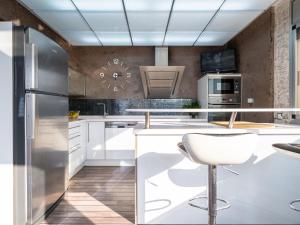 una cocina con armarios blancos y una silla blanca en Villa Villa Luxury Rock Tirri by Interhome en Reus
