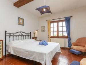 a bedroom with a white bed and a chair at Holiday Home Can Maggi by Interhome in Calonge