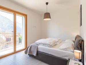 a bedroom with a bed and a large window at Apartment Casa Tondi by Interhome in Porlezza