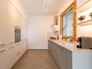 a kitchen with white cabinets and a window at Apartment Casa Tondi by Interhome in Porlezza