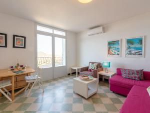 ein Wohnzimmer mit einem rosa Sofa und einem Tisch in der Unterkunft Apartment Chantelyre-2 by Interhome in Carqueiranne