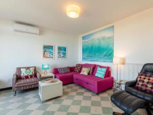 ein Wohnzimmer mit einem rosa Sofa und Stühlen in der Unterkunft Apartment Chantelyre-2 by Interhome in Carqueiranne