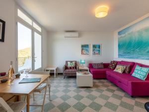 ein Wohnzimmer mit einem lila Sofa und einem Tisch in der Unterkunft Apartment Chantelyre-2 by Interhome in Carqueiranne
