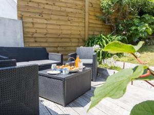 a patio with wicker chairs and a table with food on it at Holiday Home Belvédère sur la Mer by Interhome in Locquirec