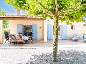 un patio con mesa, sillas y un árbol en Holiday Home Le Jardin du Golf by Interhome en Nans-les-Pins