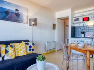 a living room with a blue couch and a table at Apartment Primavéra-12 by Interhome in Lacanau-Océan