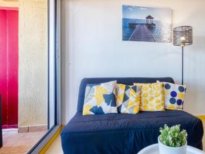 a blue couch with pillows in a living room at Apartment Primavéra-12 by Interhome in Lacanau-Océan