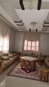 a living room with two beds and a table in it at فيلا المصري in Chichaoua