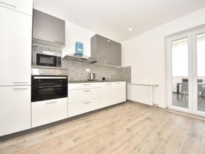 a kitchen with white cabinets and a large window at Apartment Franka by Interhome in Pašman +35 photos