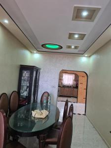 una sala da pranzo con tavolo in vetro e sedie di فيلا المصري a Chichaoua