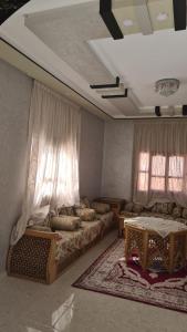 a living room with two beds and two windows at فيلا المصري in Chichaoua