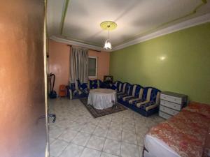 een slaapkamer met een bank en een tafel in een kamer bij إقامة المقاومة قرب سوق الحد اكادير in Agadir