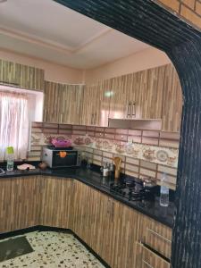 a kitchen with a black counter top and wooden cabinets at فيلا المصري in Chichaoua