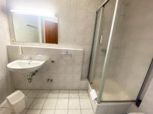 a bathroom with a shower and a sink and a toilet at Limok Rooms Hamm in Hamm