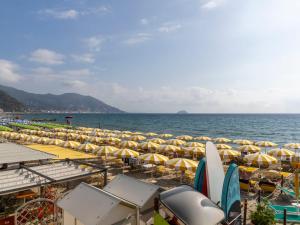une plage avec beaucoup de parasols et l'océan dans l'établissement Apartment Attic Beach by Interhome, à Laigueglia
