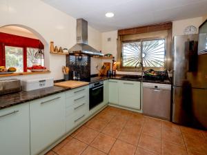 una cocina con armarios blancos y electrodomésticos de acero inoxidable en Holiday Home Mas Altaba by Interhome, en Maçanet de la Selva