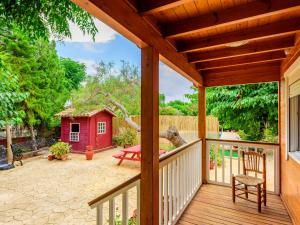 une terrasse en bois avec un banc et une maison rouge dans l'établissement Holiday Home La Alqueria de Jordi by Interhome, à El Grao de Castellón