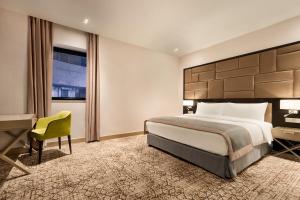 a hotel room with a bed and a desk at Wyndham Grand Tbilisi in Tbilisi City