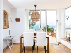 una sala da pranzo con tavolo, sedie e vista sull'oceano di Villa Helene by Interhome a Nerja