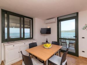 una cucina e una sala da pranzo con tavolo e sedie di Apartment Donatella by Interhome a Cannigione Altre 30 foto