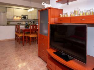 a living room with a flat screen tv and a kitchen at Apartment Colom by Interhome in Malgrat de Mar