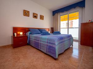 a bedroom with a bed and a large window at Apartment Colom by Interhome in Malgrat de Mar